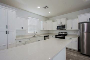 Tempe apartment for rent - a kitchen with white cabinets and stainless steel appliances