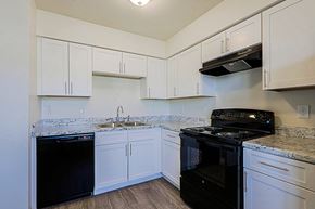 Phoenix apartment for rent - A kitchen with white cabinets and black appliances.