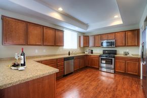 Phoenix townhouse for rent - a kitchen with wooden cabinets and granite counter tops and a stainless steel stove and microwave