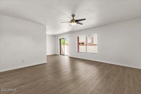 Phoenix apartment for rent - an empty living room with a ceiling fan and a window