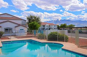 Thatcher apartment for rent - a swimming pool with a building and mountains in the background