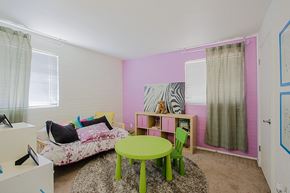 Phoenix apartment for rent - a room with pink walls and a green table and chairs