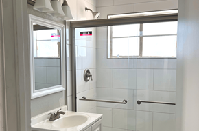 Phoenix apartment for rent - A white sink in a bathroom with a glass shower door.