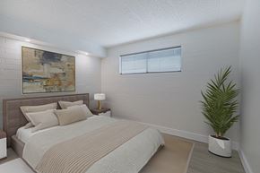 Phoenix apartment for rent - A bedroom with a bed, lamp, and a painting on the wall.