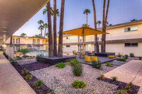 Phoenix apartment for rent - A yellow umbrella is in front of a building with a balcony.