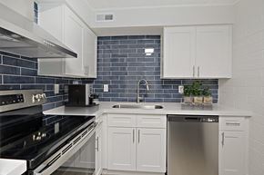 Phoenix apartment for rent - A kitchen with white cabinets and a black stove top oven.
