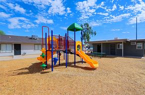 Goodyear apartment for rent - A playground with a yellow slide and a green canopy.