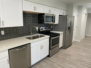 Scottsdale apartment for rent - A kitchen with white cabinets and a black backsplash.