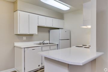 Glendale apartment for rent - a kitchen with white cabinets and a sink and a refrigerator