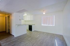 Phoenix apartment for rent - the living room and kitchen of an apartment with white walls and wood flooring