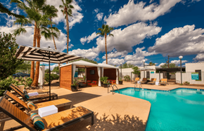 Scottsdale apartment for rent - A pool area with a sun lounger and a striped umbrella.