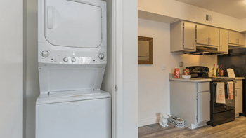 A white washer and dryer in a room next to a kitchen