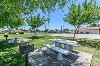 Private picnic areas with two grills and two while picnic tables with benches 