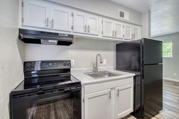 Mesa apartment for rent - the preserve at ballantyne commons apartment kitchen with black appliances and white cabinets