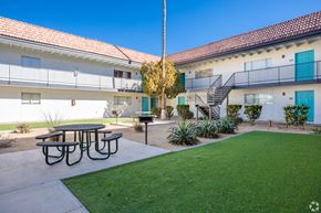 Mesa apartment for rent - a courtyard with a picnic table and a lawn in front of a building