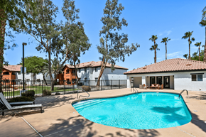 Yuma apartment for rent - A swimming pool surrounded by trees and a fence.