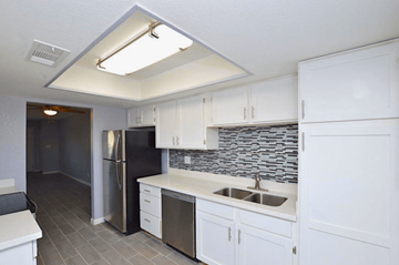 Phoenix apartment for rent - a kitchen with white cabinets and a stainless steel refrigerator