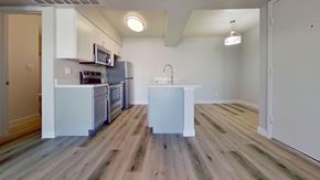 Phoenix apartment for rent - A kitchen with a white fridge and wooden floors.
