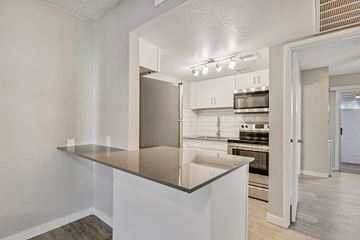 Phoenix apartment for rent - A kitchen with a stainless steel refrigerator and white cabinets.