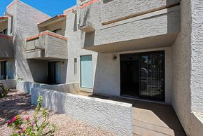 Scottsdale townhouse for rent - A building with a grey facade and a blue door.