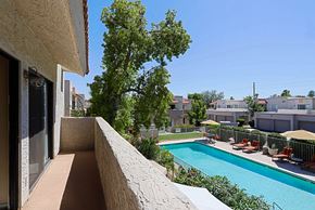 Scottsdale townhouse for rent - A pool with chairs and a tree in the background.