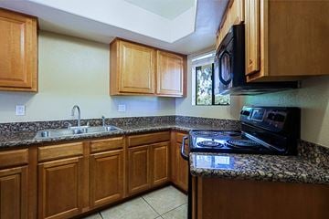 Scottsdale townhouse for rent - A kitchen with wooden cabinets and granite countertops.