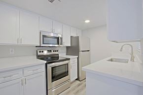 Mesa apartment for rent - a kitchen with white cabinets and stainless steel appliances