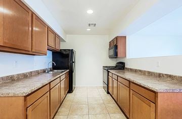 Goodyear apartment for rent - A kitchen with brown cabinets and granite countertops.