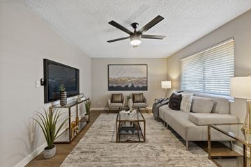 Phoenix apartment for rent - A living room with a grey couch, a coffee table, and a painting on the wall.