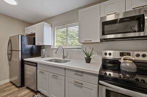 Phoenix apartment for rent - A modern kitchen with white cabinets and stainless steel appliances.