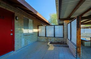 Phoenix apartment for rent - A red door is on the left side of a brick building.