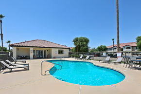Yuma apartment for rent - A swimming pool with lounge chairs and a building in the background.