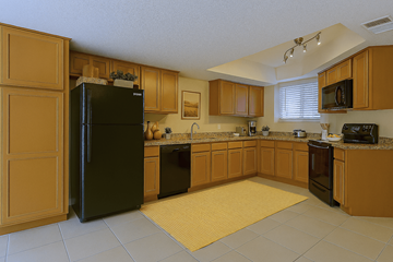 Scottsdale townhouse for rent - A kitchen with wooden cabinets and a black fridge.