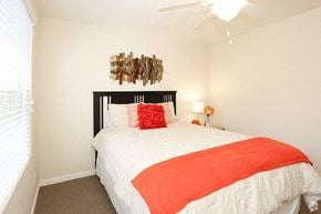 Tempe apartment for rent - a bedroom with a white bed and an orange blanket