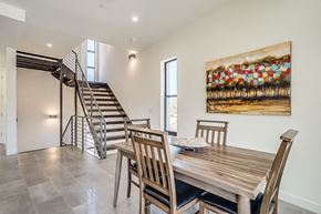 Scottsdale townhouse for rent - a dining room with a wooden table and chairs and a staircase