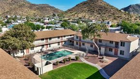 Phoenix apartment for rent - A large house with a pool in the middle of a grassy area.