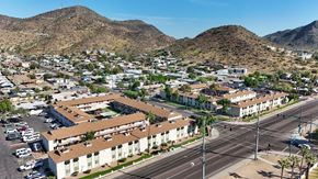 Phoenix apartment for rent - A large apartment complex is surrounded by a parking lot and a road.