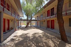 Tempe apartment for rent - a courtyard with trees and red doors