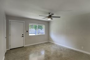 Phoenix apartment for rent - an empty living room with a ceiling fan and a window