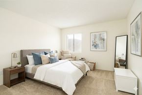 Phoenix apartment for rent - A bedroom with a large bed and a nightstand with a lamp.