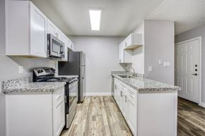 Phoenix apartment for rent - A kitchen with white cabinets and a granite countertop.