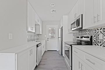 Phoenix apartment for rent - A white kitchen with a tile backsplash and a window.
