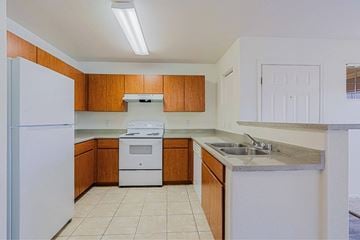 Wickenburg apartment for rent - A kitchen with white appliances and wooden cabinets.