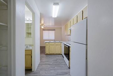 Wickenburg apartment for rent - A kitchen with a white refrigerator and wooden cabinets.