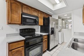 Wickenburg townhouse for rent - A kitchen with black appliances and wooden cabinets.
