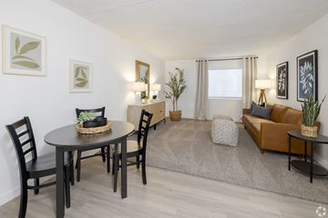 Mesa apartment for rent - A living room with a brown couch, a round table with chairs, and a rug.