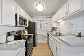 Scottsdale apartment for rent - A kitchen with white cabinets and a black refrigerator.