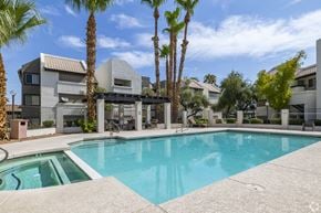 Glendale apartment for rent - a swimming pool with palm trees in front of an apartment building