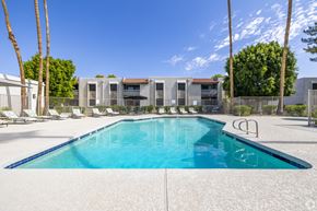 Scottsdale apartment for rent - A swimming pool in front of a building with palm trees.