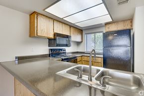 Scottsdale apartment for rent - A kitchen with a stainless steel sink and wooden cabinets.